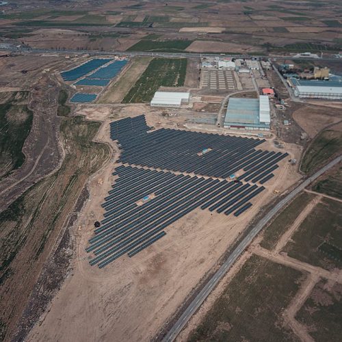 Expansive view of solar panels in a rural landscape, showcasing renewable energy.